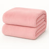 Een Teddy fleece hoeslaken - 90x200 cm in zachtroze is netjes gevouwen op een effen witte achtergrond.