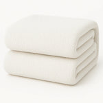 Een gevouwen Teddy fleece hoeslaken - 90x200 cm, extra warm, in wit op een effen witte ondergrond.